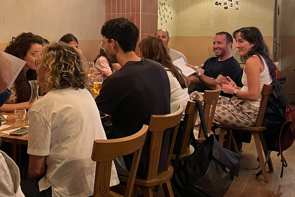 Une tablée qui rit pendant une soirée d'échange