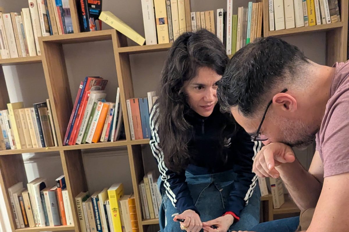Un binôme penché sur ses fiches devant la bibliothèque